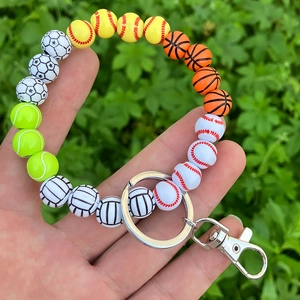 Close-up of sports ball wooden bead keychain bracelet with soccer, basketball, and baseball
