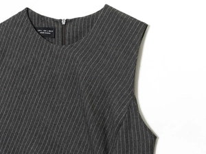Detail of grey striped sleeveless dress neckline with size label and zipper texture
