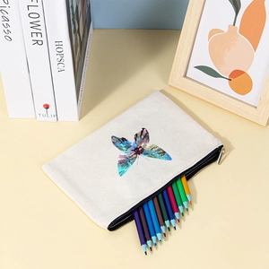Detail of canvas pouch showing butterfly print and zipper filled with pencils