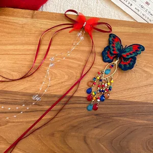 Elegant Chinese butterfly hair clip with colorful crystal tassels on a rustic wood background