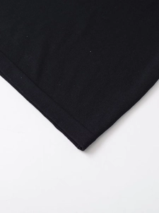 Detailed macro view of black fine-knit fabric texture and neat edge stitching on T-shirt