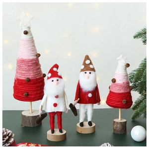 Detail of wool felt gnomes and pink yarn Christmas trees on a wooden base for decor