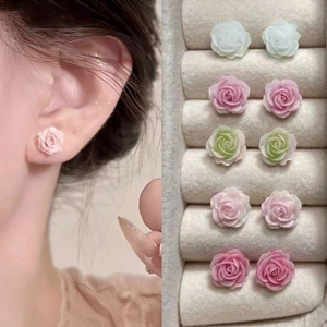 Macro shot of colorful resin rose stud earrings set in various pastel floral styles