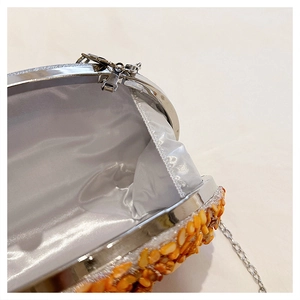 Detail view of pumpkin shaped evening bag featuring orange fragments and silk lining