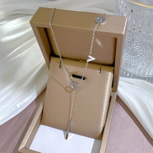 Silver LOVE letter necklace with vertical bar pendant in a gold gift box on white silk