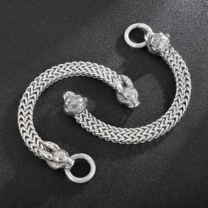 Close-up of vintage silver zodiac rabbit head charms on double-braided chain bracelets
