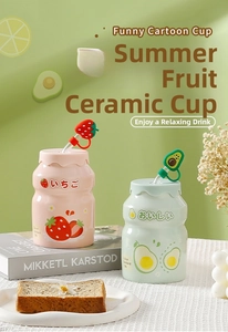 Detail of strawberry and avocado ceramic mugs with silicone fruit straw covers