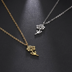 Macro detail of gold and silver hollow flower necklaces on black textured background