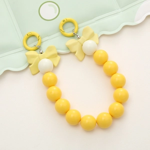 Detail of candy color acrylic beaded phone charm with yellow bow and metal hooks
