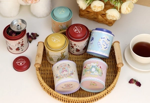 Detail view of colorful round tin containers with floral patterns in a lifestyle setting