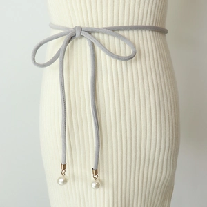 Detail of grey velvet waist rope with white pearl pendants on a knitted dress
