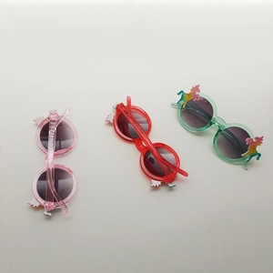 Close-up of colorful unicorn children's sunglasses with glitter finish and wing details