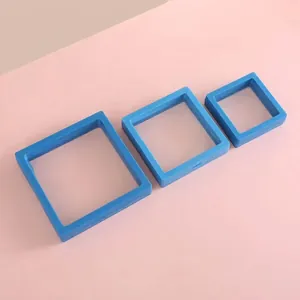 Three blue 3D floating jewelry display frames in different sizes on pink background