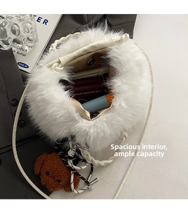 Spacious interior of white faux fur bucket bag with magnetic closure and bear charm
