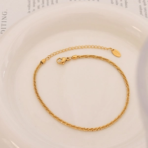 Sparkling 18k gold plated stainless steel leg chain with unique wave texture on white plate