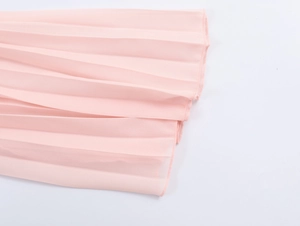 Close-up of pink pleated chiffon fabric showing detailed texture and hem finish