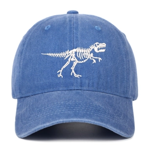 Close-up of white dinosaur skeleton embroidery on washed denim blue baseball cap
