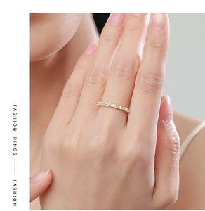 Detail of 925 silver pearl ring on model's finger with elegant golden band design