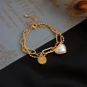 Double-layered gold chain bracelet with heart pearl and engraved circular pendant charms