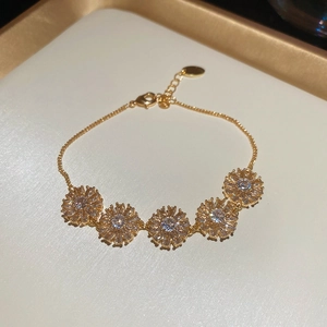 Detail of gold plated flower bracelet with zircon petals and adjustable lobster clasp