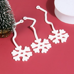Macro detail of white snowflake ornaments with wavy strings on festive red background