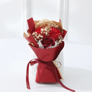 Close-up of artificial red roses and dried baby's breath in red and gold wrapping