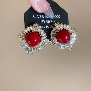 Macro shot of French vintage earrings with large red pearls and sparkling zircon halos