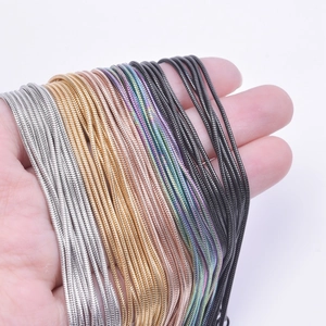 Multiple colors of 1.2mm stainless steel snake chain necklaces held in hand