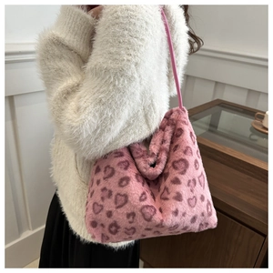 Detail of a pink fuzzy tote bag with heart leopard print patterns in a lifestyle setting