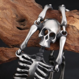 Macro detail of gothic skull link in antique silver finish on a rustic wooden background
