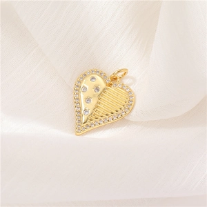Detailed view of a gold heart pendant with micro-pave zircons and striped texture