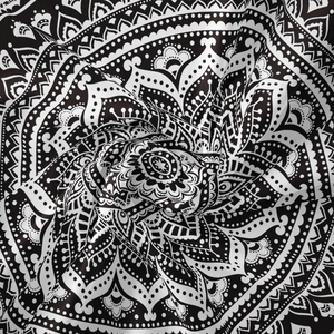 Detailed close-up of bohemian mandala tapestry fabric with black and white patterns