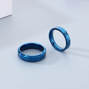 Detailed view of two blue plated tungsten rings featuring a hammered texture surface