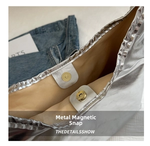 Detailed close-up of the silver tote bag showing its metallic magnetic buckle and lining