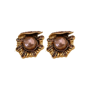 Vintage style gold-tone shell earrings with dark pearls and crystals on white background