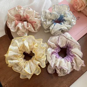 Set of four floral lace scrunchies in pastel colors on a rustic wooden tray decoration