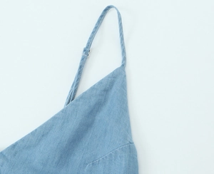 Détail de la fine bretelle réglable sur une robe midi en jean bleu avec boucle
