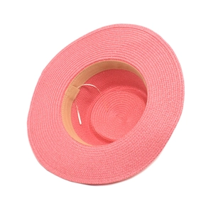 Detailed view of pink woven straw sun hat with inner sweatband and elastic wind rope