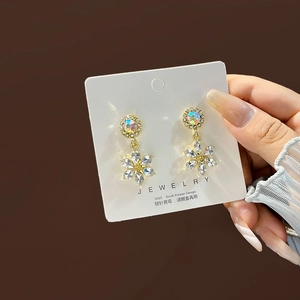 Macro shot of S925 silver flower earrings with sparkling crystals and golden finish