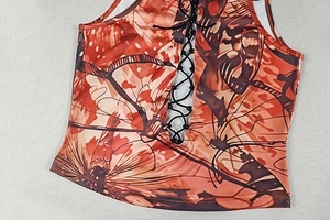 Detail of butterfly print camisole featuring black lace-up corset front design