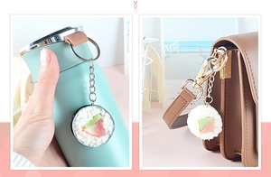 Portachiavi sushi in PVC realistico appeso a una tazza blu e una borsa in pelle