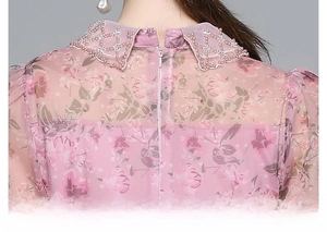 Détail d'une robe en tulle fleuri avec col perlé et fermeture éclair invisible au dos