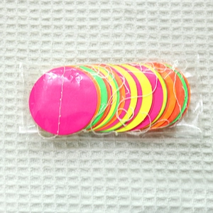 Macro shot of colorful neon paper garlands packaged in a clear plastic bag for parties