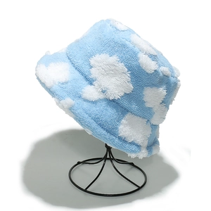 Detailed close-up of blue teddy plush bucket hat with cloud patterns on display stand