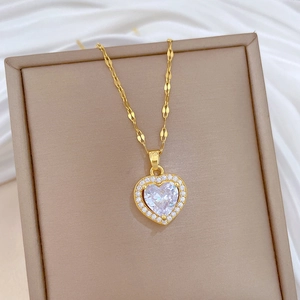 Detailed close-up of a heart-shaped gold pendant necklace with cubic zirconia on silk
