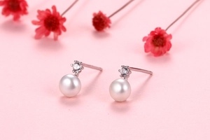 Macro shot of freshwater pearl earrings with silver base and sparkling cubic zirconia