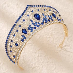 Luxury gold bridal crown with brilliant blue and white crystals on beige fabric