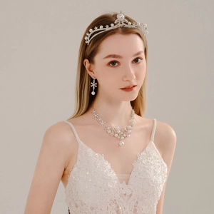 Detail view of bridal jewelry set with pearls and rhinestones worn by a model