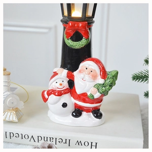 Detail of festive Christmas resin lamp ornament with Santa Claus and Snowman on a warm street light