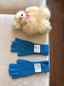 Detalle de guantes de punto de lana azul con una etiqueta de marca vintage en el puño